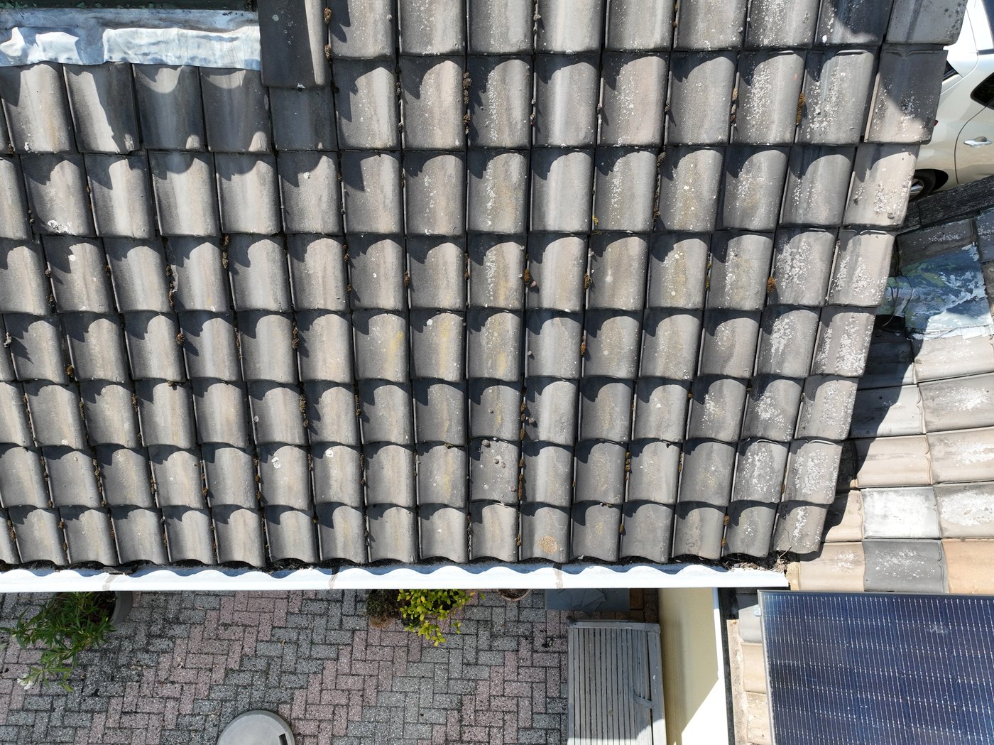 Dronefoto van dakpannen, dakrand en dakgoot van bovenaf