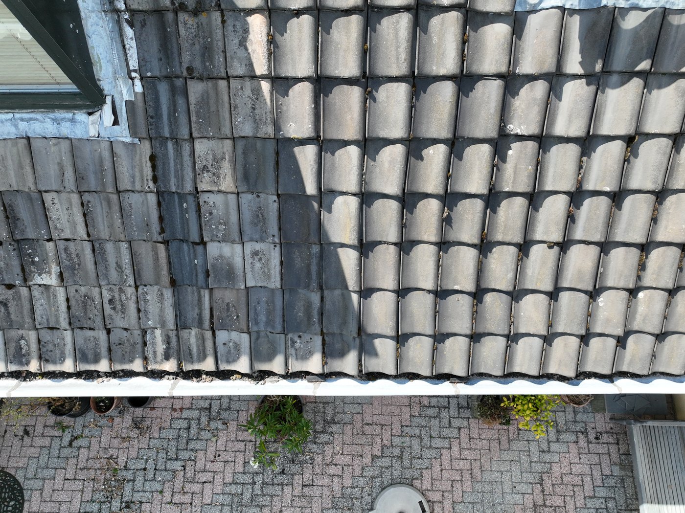 Dronefoto van dakpannen en aansluiting bij een dakraam