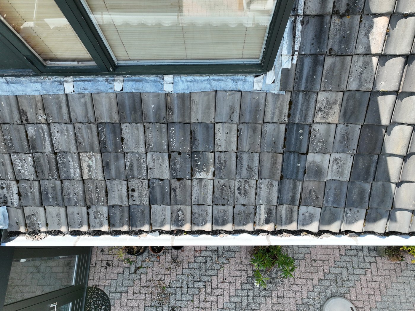 Detailbeeld van dakrand en dakpannen bij een dakraam